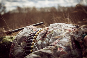 Tired hunter man having a rest in rural field after long hunting day