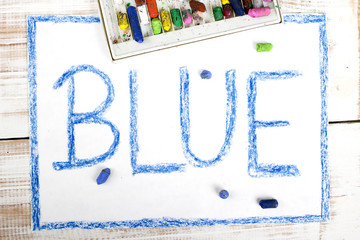word BLUE written in blue crayon on paper