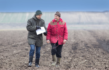 Farmers on plowed field