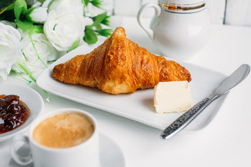 Breakfast with coffee, croissant and strawberry jam