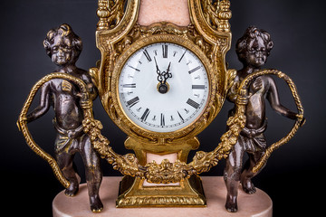 Antique clock on black background