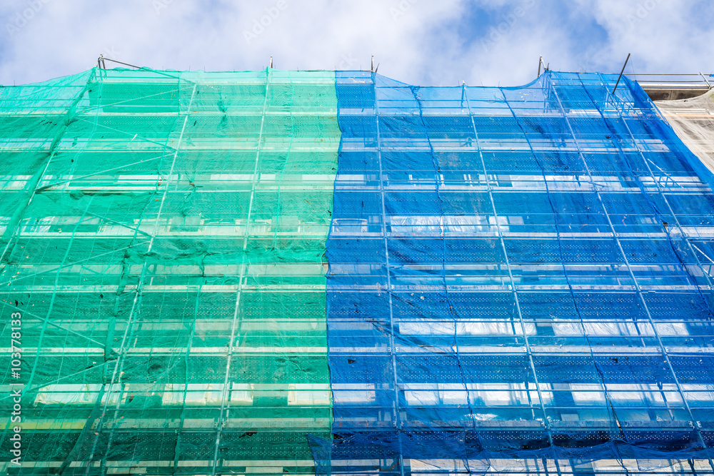 Wall mural scaffolding and protective netting on the building