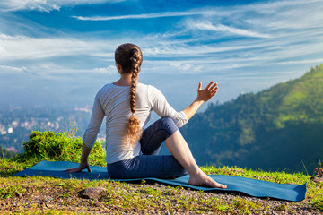 Fototapeta na wymiar Woman practices yoga asana Marichyasana 