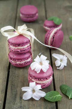 Sweet crimson french macaroons  wiht hyacinth flowers and mint on dark wooden background