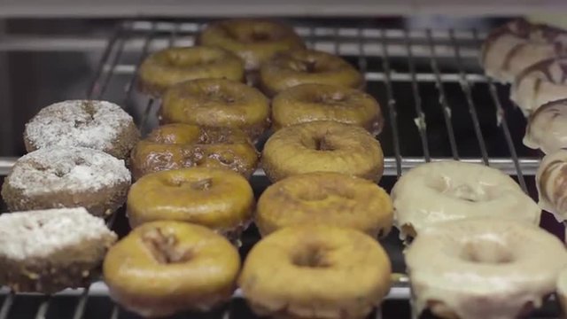 Slow, close up tracking shot of donuts in a bakery