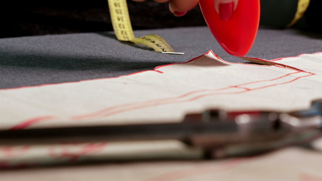 Designer measuring cloth for sewing with chalk