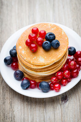 Stack of pancakes with blueberry and fresh berry.
