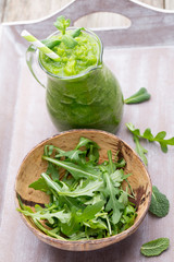 Rucola smoothie, on the grey  background.