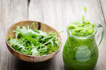Rucola smoothie, on the grey  background.