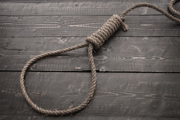 Obraz premium Running knot.Loop hempen ropeon on a dark wood tables background. 