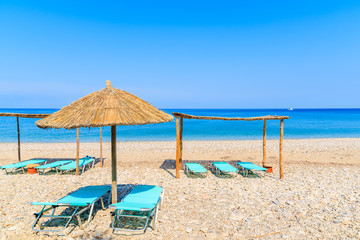 Sunchairs with umbrellas on Potami beach, Samos island, Greece
