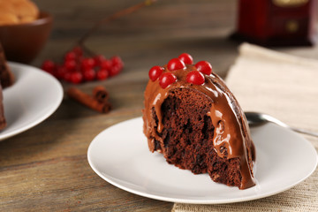 Piece of chocolate cake with snowball tree berries on a table