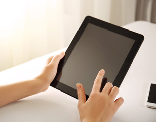 Mobile phone and female hands using modern tablet, indoors