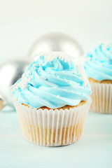 Few tasty blue cupcakes with decorations on light background