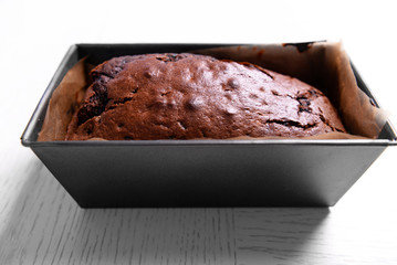 Chocolate cake in baking dish on white table
