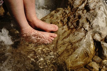 Woman feet in a mountain stream