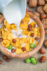 Healthy cornflakes with milk and nuts for breakfast
