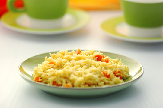 Stewed rice with a carrot on a plate