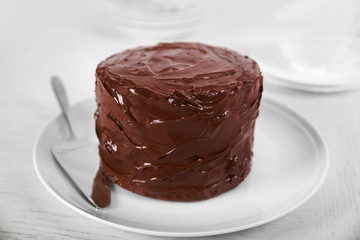 Chocolate cake on a plate with blade on light background