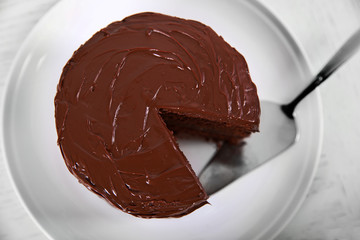 Chocolate cake on plate with a cut piece view from above