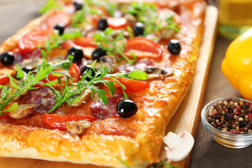 Rectangle delicious pizza and vegetables on the table, close-up