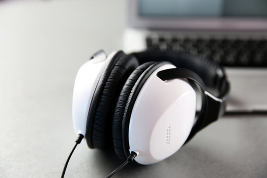 Headphones and laptop on table closeup