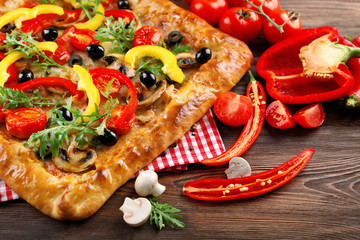 Freshly homemade pizza on wooden table closeup
