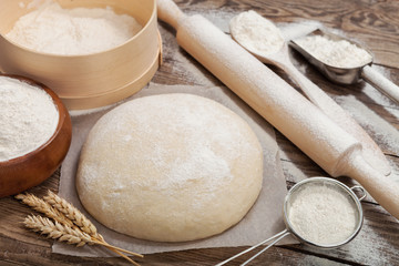 Dough and rolling-pin on wooden table
