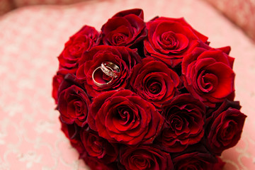Beautiful red wedding bouquet with engagement rings