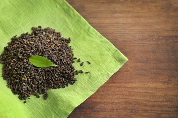 Granulated tea with green leaves on sackcloth closeup