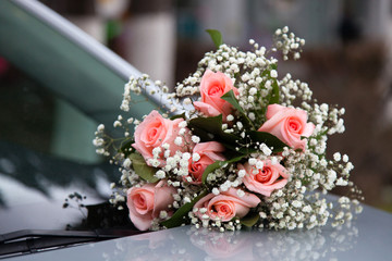 Wedding bouquet on the hood of the car