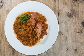 Cassoulet Toulousain from above. French restaurant prepared stew with beans and a variety of pork sausages, served with rosemary
