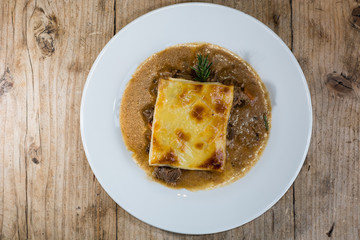 Steak and kidney pie from above. French restaurant prepared cuisine influenced by a traditional English recipe, presented on a white plate
