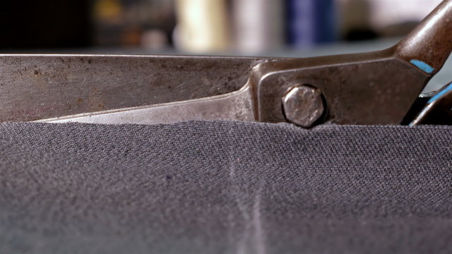 Designer at work cutting piece of black cloth