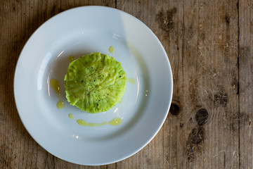 Green mashed potato with parsley, from above wide. French restaurant prepared mash, green due to inclusion of parsley, with olive oil and peppercorns
