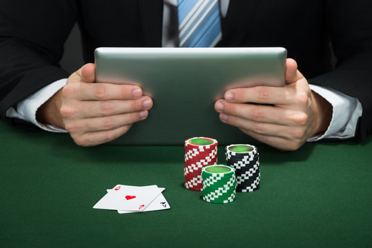 Poker Hand Holding Digital Tablet