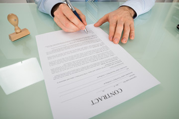 Person Hand Signing Contract Form