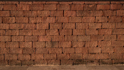 A wall of old red brick with aged different color. The crack and some wreckage can be found all over the wall. Vintage