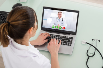 Female Doctor Video Chatting On Laptop