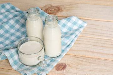 Milk bottle and milk glass put on wooden.