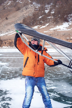 Man standing on ice with wing in the hands.