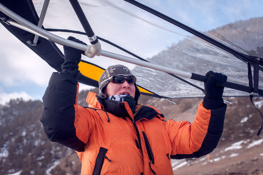 Man standing on ice with wing in the hands.