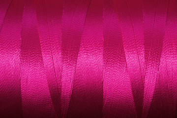 Close up of a spool of synthetic pink thread