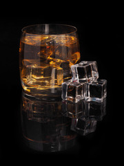 glass of whiskey and ice on a black background
