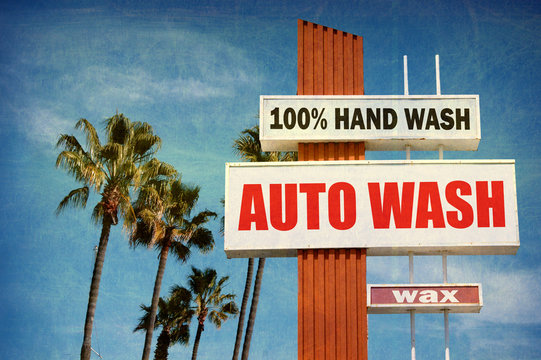 aged and worn vintage photo of auto wash sign with palm trees