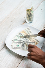  hand eating banknotes symbolising consumerism and corruption