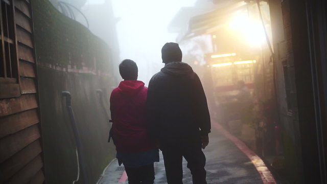 Asian senior couple walking and holding hands together in the mist. Travel and see the world together