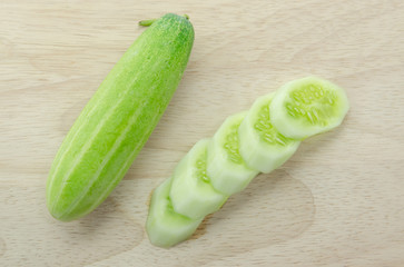 Cucumber slices on wooden board.