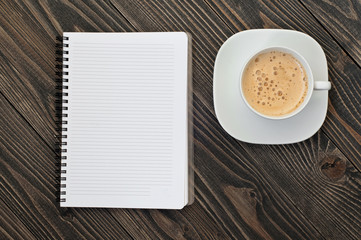 Obraz na płótnie Canvas Notepad with blank pages and cup of coffee