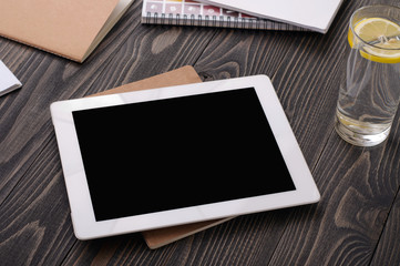 Workplace with white tablet computer with a blank screen